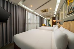 a bedroom with two white beds and a window at Bella Rosa Hotel & Travel in Hanoi