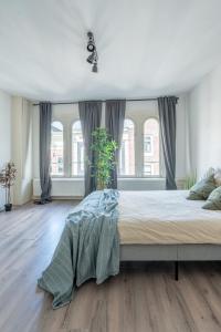 sypialnia z dużym łóżkiem i oknami w obiekcie Penthouse Amsterdam Dam Square w Amsterdamie