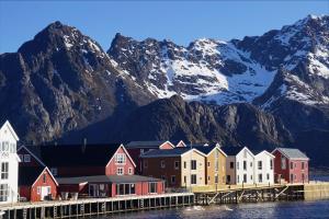 a row of houses in front of a mountain at Henningsvær Bryggehotell - by Classic Norway Hotels in Henningsvær