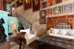 una sala de estar con sofá y una escalera con pinturas en Es Revellar Art Resort - Adults Only, en Campos