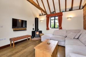 a living room with a couch and a fireplace at Finest Retreats - Flint Barn in Faversham