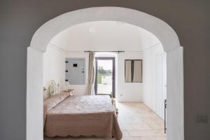 a bedroom with a bed in a white room at Masseria Donna Coletta by Wonderful Italy in Noci