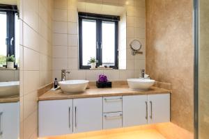 a bathroom with two sinks and a mirror at Finest Retreats - Flint Barn in Faversham +24 photos