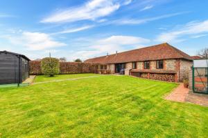 eine Außenansicht eines Hauses mit einem großen Hof in der Unterkunft Finest Retreats - Flint Barn in Faversham