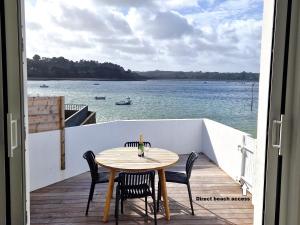 Una mesa y sillas en un balcón con vista al agua. en Holiday Home in Plougasnou with Sea Views, en Plougasnou 12 fotos más