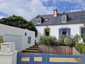 una casa blanca con una valla azul en Holiday Home in Plougasnou with Sea Views, en Plougasnou