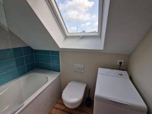 łazienka z toaletą, umywalką i oknem dachowym w obiekcie Small premium cottage, a nugget by the sea w mieście Plougasnou