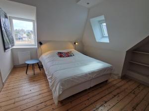 niewielka sypialnia z łóżkiem i 2 oknami w obiekcie Small premium cottage, a nugget by the sea w mieście Plougasnou
