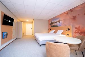 Habitación de hotel con cama, mesa y sillas en Fletcher Hotel-Restaurant de Borken en Dwingeloo