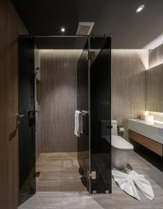 a bathroom with a shower with a toilet and a sink at Luminous Resort & Spa by Areca in Phuket Town