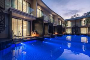 ein großes Schwimmbecken in einem Gebäude mit blauer Beleuchtung in der Unterkunft Luminous Resort & Spa by Areca in Phuket