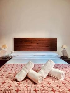 Una cama con dos toallas enrolladas. en Central, near the Alhambra, quiet and autentic!, en Granada