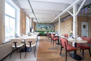 un restaurante con mesas, sillas y ventanas en Fletcher Hotel-Restaurant de Borken en Dwingeloo