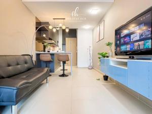 a salon with a couch and a tv in a room at The Luxe KLCC View Sky Pool in Kuala Lumpur