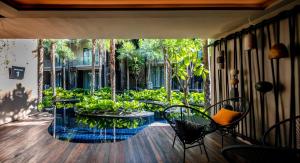 a balcony with a table and chairs and trees at Luminous Resort & Spa by Areca in Phuket Town