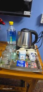 een dienblad met een waterkoker en andere artikelen op een tafel bij Kashi dham Homestay ( close to Kashi Vishwanath temple and Ghats) in Varanasi