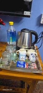 a tray with a tea kettle and other items on a table at Kashi dham Homestay ( close to Kashi Vishwanath temple and Ghats) in Varanasi