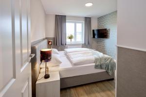 a bedroom with a bed and a window at Landgut Basthorst in Crivitz