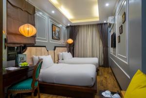 a hotel room with two beds and a desk at Bella Rosa Hotel & Travel in Hanoi