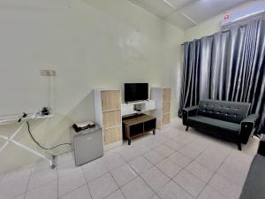 sala de estar con sofá y TV en Homestay Harmoni With Wifi and Android TV, en Pekan