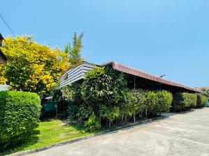 un edificio con plantas a su lado en Ruen Orathai Resort, en Prachuap Khiri Khan