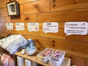 a room with a wooden wall with signs on it at EZO HOUSE in Kawayu +19 photos