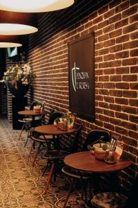 a row of tables and chairs against a brick wall at Penzion U Kubesa - Adults only in Kroměříž