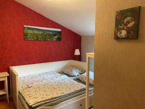 a bedroom with a bed and a red wall at Ferienhof"WaldEsel Rippersroda" in Rippersroda