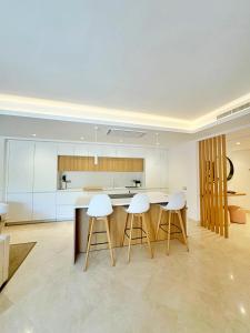une cuisine avec des comptoirs et des tabourets blancs dans l'établissement Luxury 4 BD Penthouse with Private Pool by Hostlovers, à Marbella