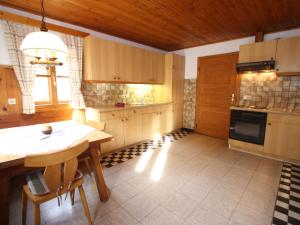 eine Küche mit Holzschränken und einem Tisch mit Stühlen in der Unterkunft Sprawling Mansion near Ski Area in Salzburg in Eben im Pongau