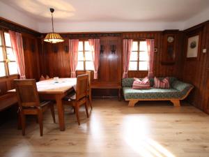 ein Esszimmer mit einem Tisch und einem Sofa in der Unterkunft Sprawling Mansion near Ski Area in Salzburg in Eben im Pongau