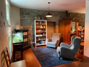 una sala de estar con 2 sillas y una pecera en Ferienhof"WaldEsel Rippersroda" en Rippersroda