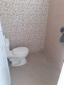 a bathroom with a toilet and a tiled wall at Cordoba residence F5 in Tlekung +11 photos