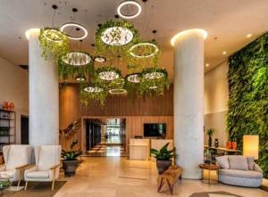 - un hall avec des chaises blanches et un grand lustre dans l'établissement Hotel GRAND M-RCURE - Itaim BiBi- Master Deluxe Veranda Duplex- First Class - Collors Edition- By HouseNN, à São Paulo