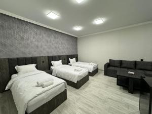 MeghriVARDANANTS HOTEL Meghri的有两张床和一张沙发的酒店房间