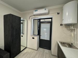 uma cozinha com uma porta preta e um lavatório em VARDANANTS HOTEL Meghri em Meghri
