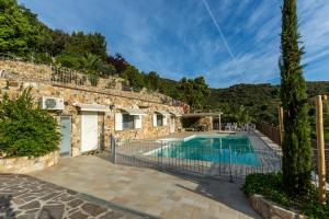 a villa with a swimming pool and a house at Borgo dell'Uccellaia - Ambra in Marciana Marina