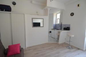 uma sala de estar com paredes brancas e pisos em madeira em Superbe studio dans le quartier du port a 5min des lignes de tramway em Nice