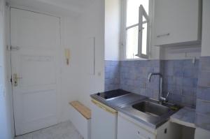 uma pequena cozinha com um lavatório e uma janela em Superbe studio dans le quartier du port a 5min des lignes de tramway em Nice