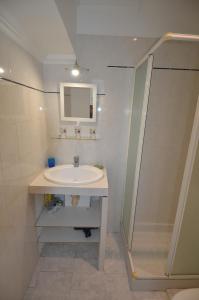 uma casa de banho branca com um lavatório e um chuveiro em Superbe studio dans le quartier du port a 5min des lignes de tramway em Nice