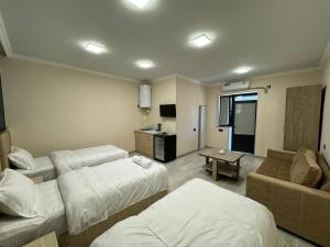 MeghriにあるVARDANANTS HOTEL Meghriのベッド2台とソファが備わるホテルルームです。