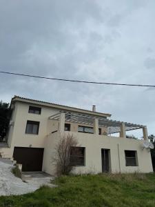 ein weißes Haus mit einer Garage davor in der Unterkunft Villa Theodora Skiathos in Skiathos-Stadt