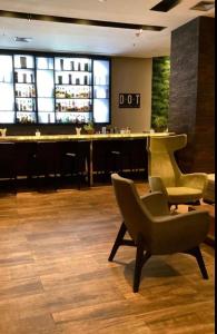 un bar avec deux chaises et un bar sidx sidx sidx sidx dans l'établissement Hotel GRAND M-RCURE - Itaim BiBi- Master Deluxe Veranda Duplex- First Class - Collors Edition- By HouseNN, à São Paulo