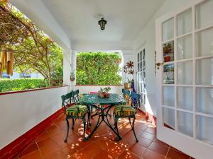 Habitación con balcón con mesa y sillas. en Charming Family Home, en Ciudad del Cabo