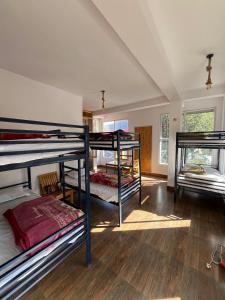 a room with three bunk beds in it at Rishi Villa in Manāli