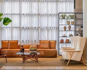 - un salon avec un canapé et une table dans l'établissement Hotel GRAND M-RCURE - Itaim BiBi- Master Deluxe Veranda Duplex- First Class - Collors Edition- By HouseNN, à São Paulo