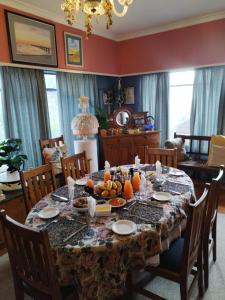 36 Mount Road Guesthouse and Self Catering في بورت اليزابيث: غرفة طعام مع طاولة مع فاكهة عليها