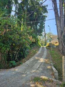 an empty road with trees on the side at Ocean's Breeze Apartment and Rooms in Puerto Viejo