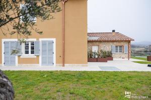 une maison avec une pelouse devant elle dans l'établissement TENUTA FOGLIANI, à Visciano