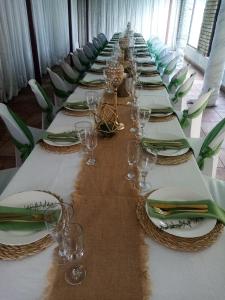 einen langen Tisch mit Tellern und Weingläsern darauf in der Unterkunft Gold Guesthouse and conferences in Welkom